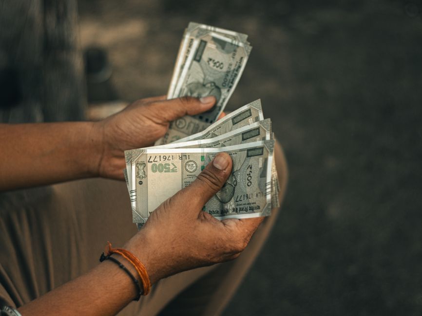 Hands counting Indian rupee notes to plan a Google Ads budget