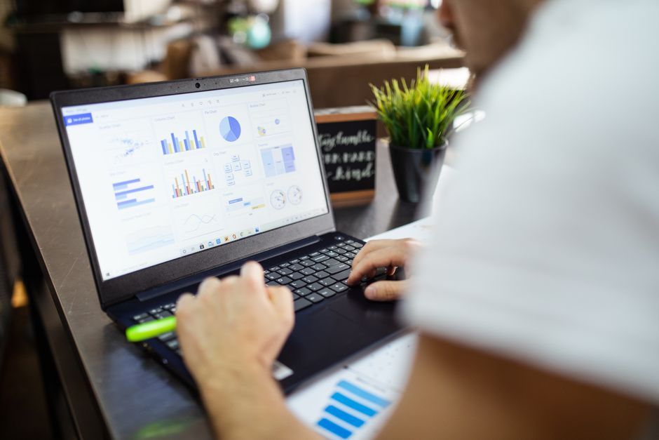 Business owner reviewing a charts dashboard on a laptop while planning ad spend