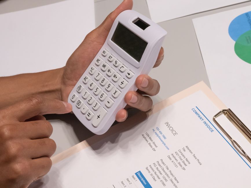 Calculator and invoice on a desk for working out cost per lead