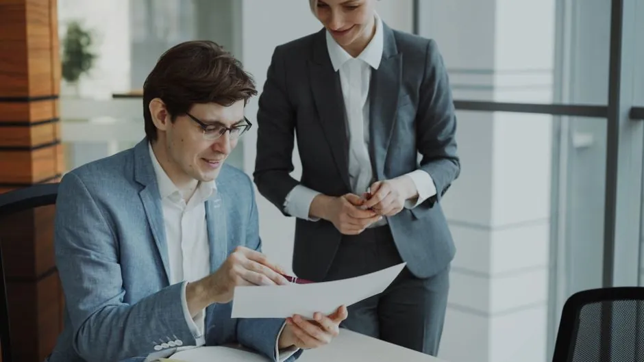 A client and consultant reviewing a digital marketing proposal document at a desk