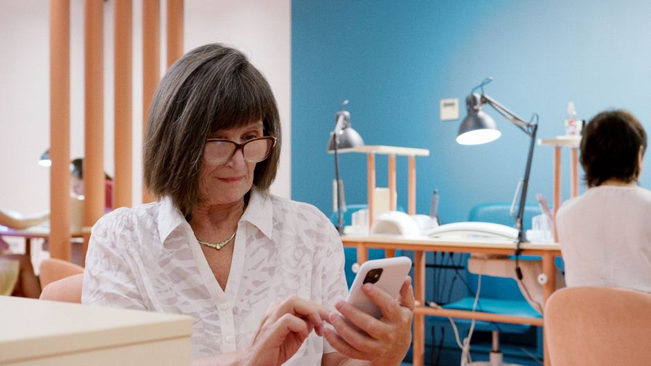 Salon owner using a phone to manage social media ads