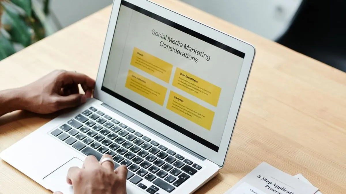 Laptop on a wooden desk showing a social media marketing slide
