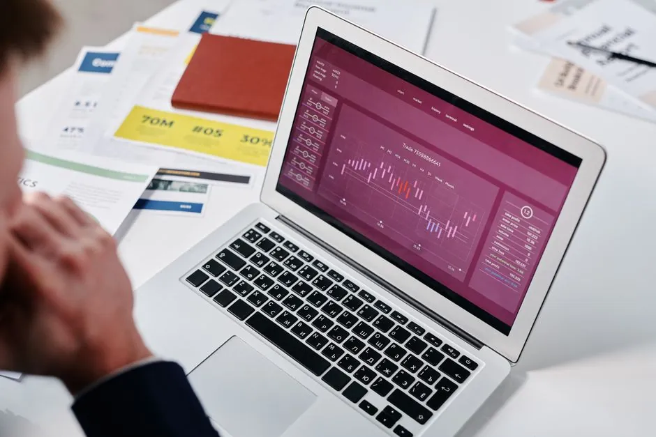 Business owner reviewing analytics on a laptop with a notepad beside it