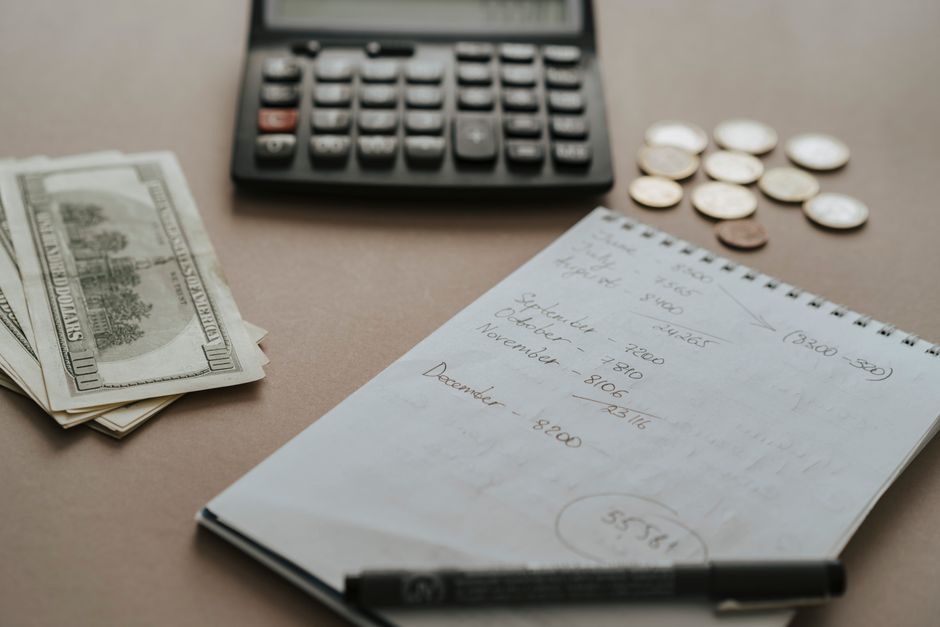 Calculator and notebook on a desk for planning a monthly marketing budget