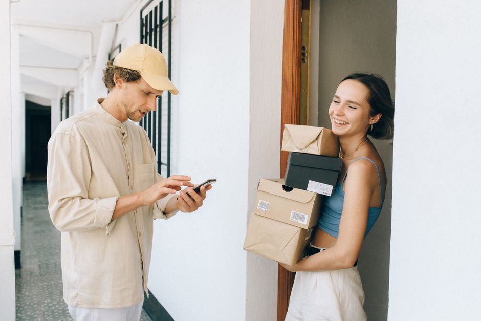 Online shopper checking a delivery notification on a smartphone as a parcel arrives