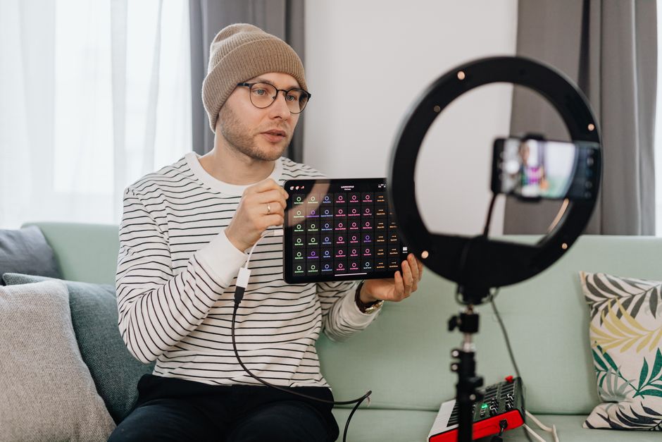 Content creator filming a product review in a Dubai studio with ring light and smartphone