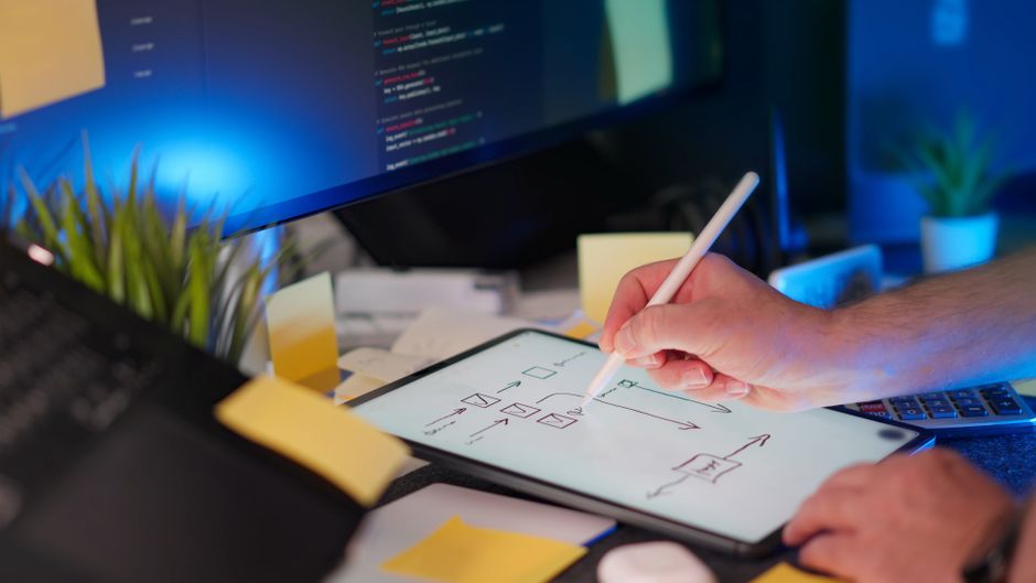 Designer sketching a website flow on a tablet