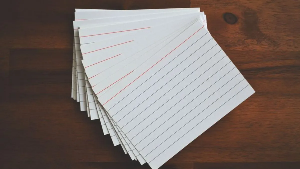 Stack of ruled index cards on a wooden desk for planning content topics