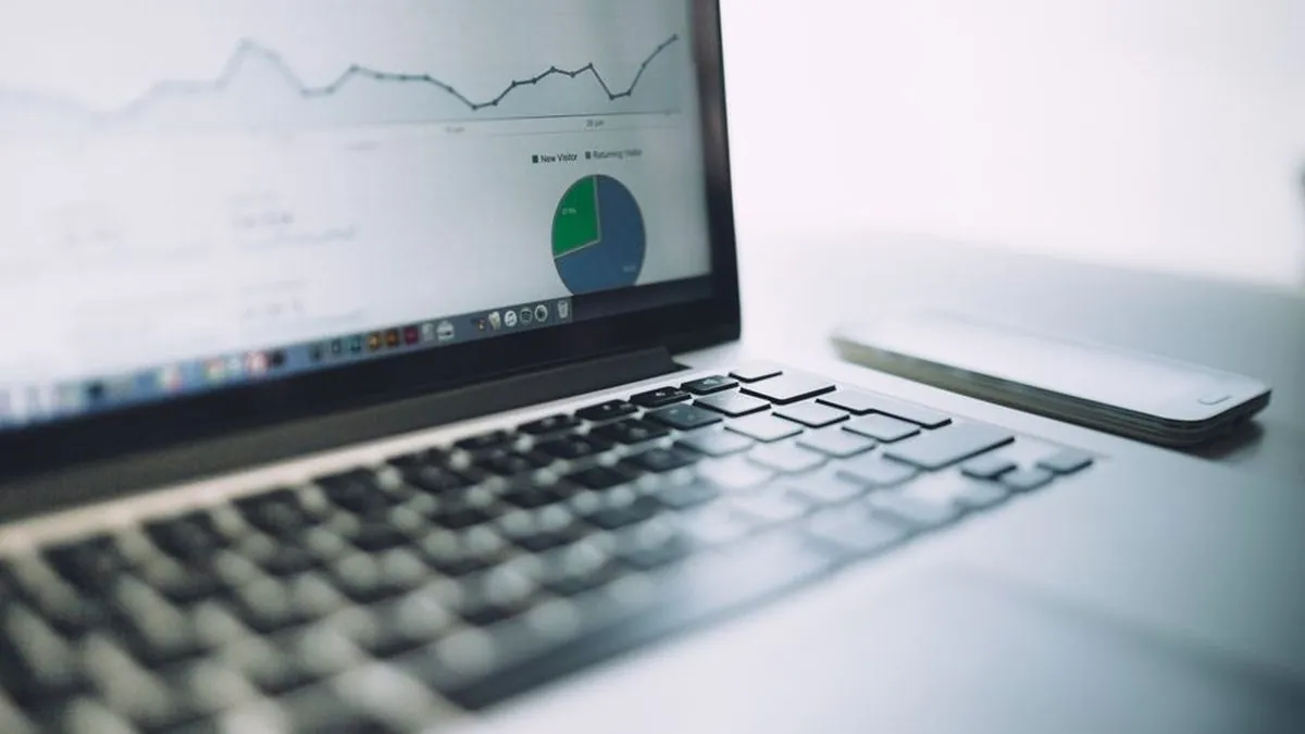Laptop screen showing a line chart and a pie chart of website analytics