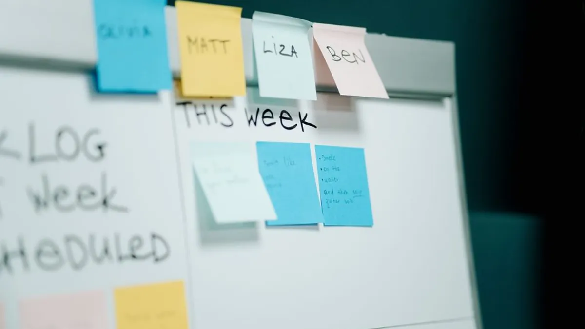 Whiteboard with weekly sticky notes used to schedule marketing tasks