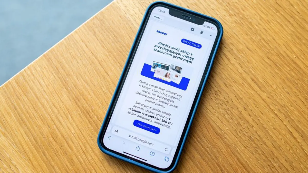 Smartphone on a wooden desk showing a website page