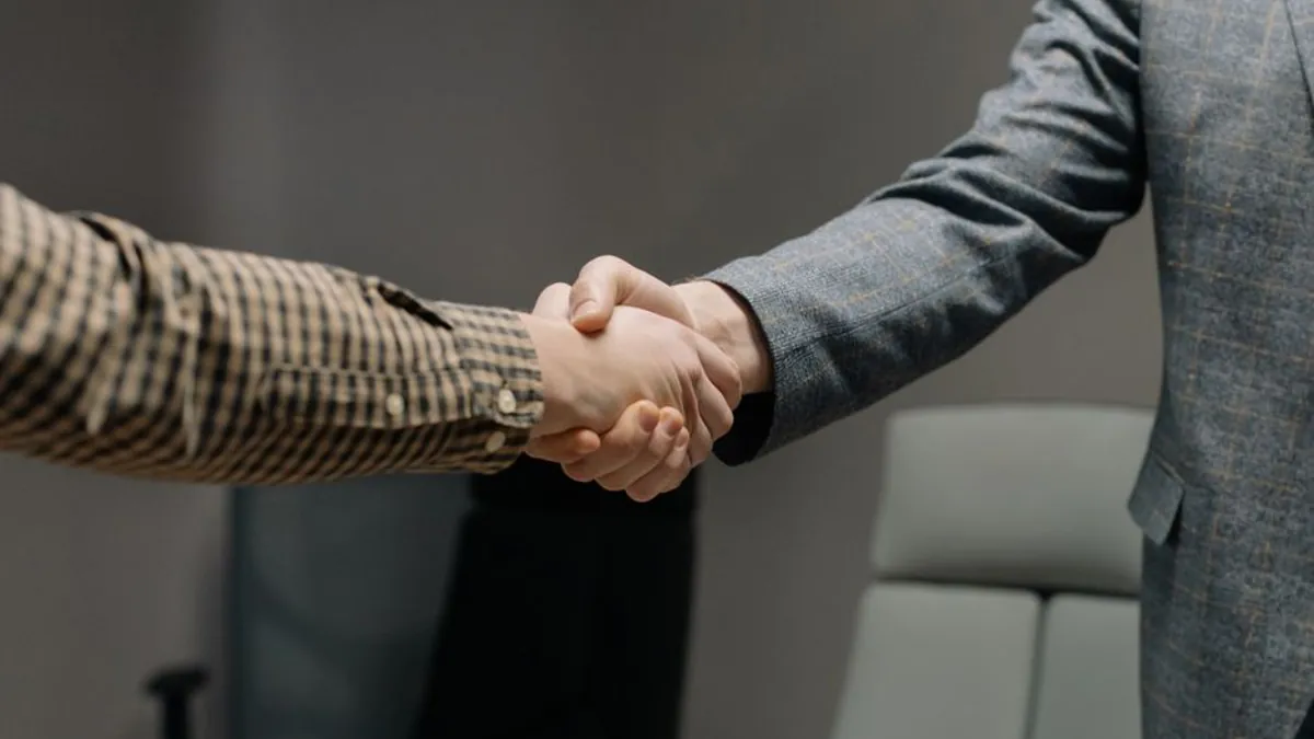 Two business people shaking hands in an office meeting