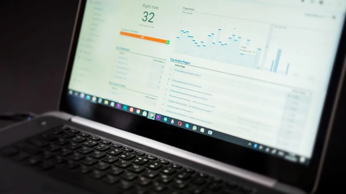 Laptop showing an analytics dashboard with traffic charts and a list of top pages