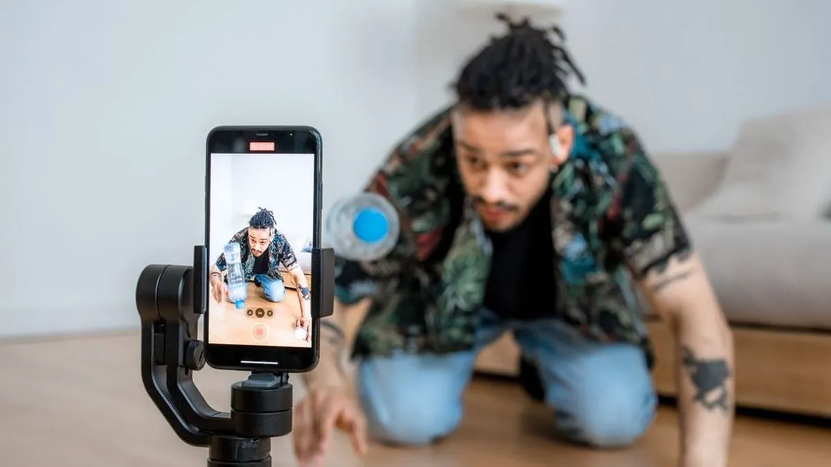 Creator filming a product demonstration with a smartphone on a gimbal at home