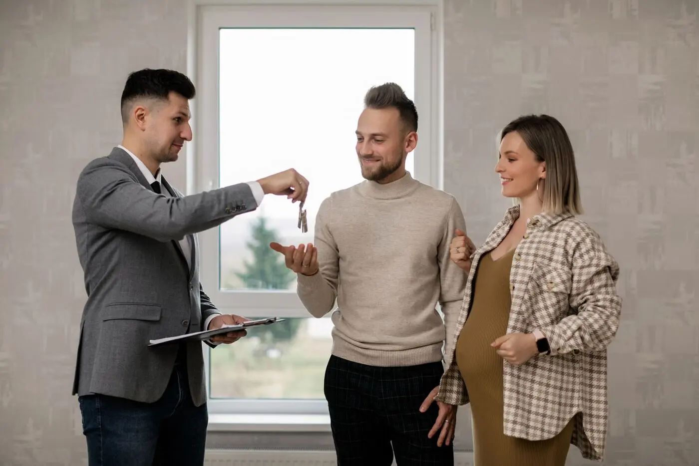 Real estate agent handing house keys to a couple